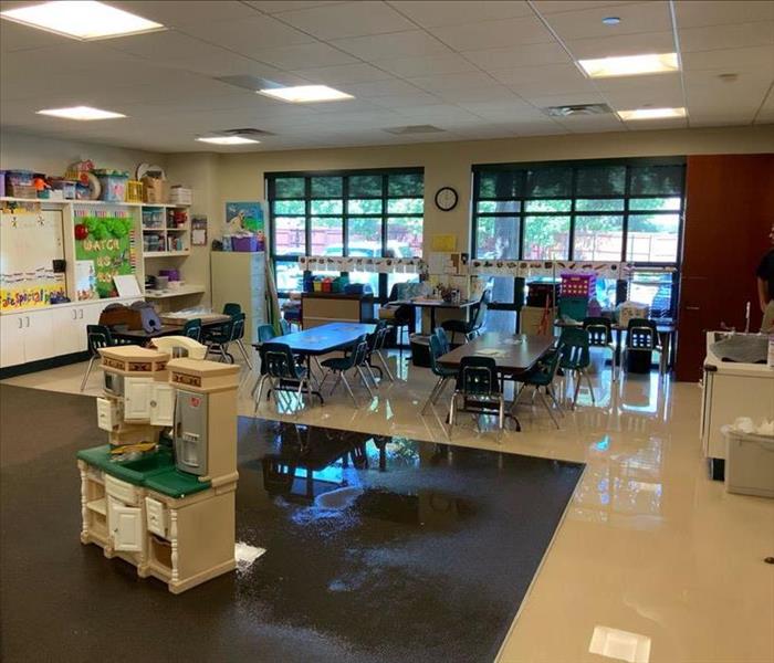 flooded children's classroom. The carpet and tile flooring is wet from a water leak. 