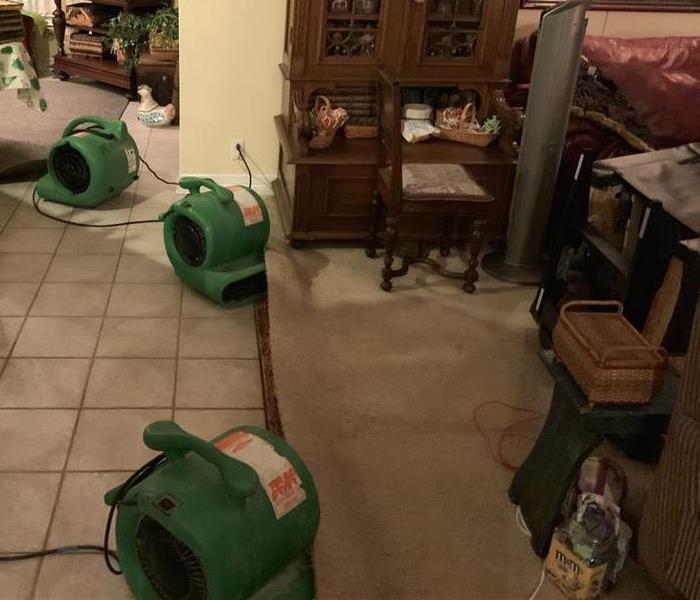 fully furnished living area, with multiple commercial grade fans being used and drying tools.