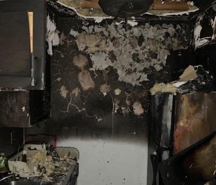 This image is of a kitchen area that caught fire. Once it was extinguished it left behind hazardous materials.