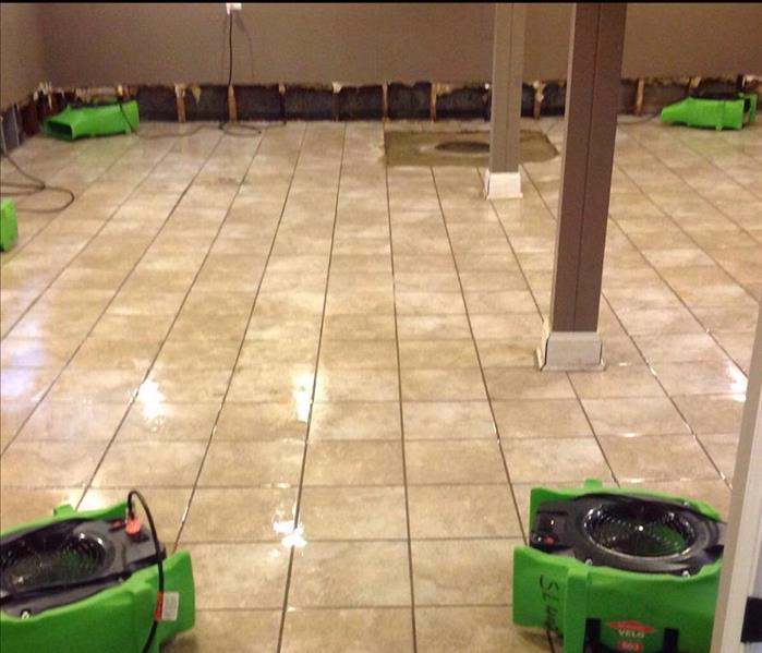 Drying fans stationed around a tiled floor.